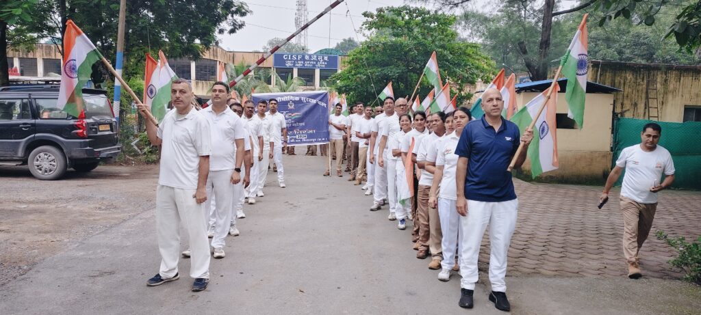 CISF एसईसीएल गेवरा क्षेत्र की हर घर तिरंगा रैली में तिरंगा लेकर आगे बढ़ते जवान और अधिकारी